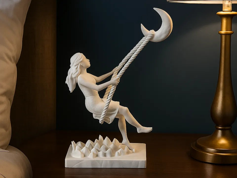 Figura decorativa branca de uma mulher suspensa numa lua crescente sobre base